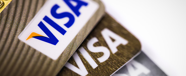 Three Visa credit cards stacked on top of each other and fanned to display the Visa logo