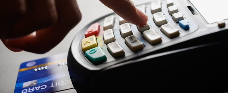 finger pushing button on credit card terminal